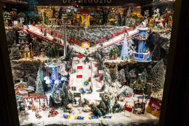 Torino, İtalya - 26 Kasım 2024: Torin veya Torino, Piedmont, İtalya 'da bir alışveriş caddesinde içinde minyatür eğlence parkı bulunan bir Noel süsü bulunan bir dükkanın sergilenmesi