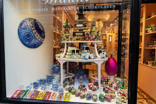 Salzburg, Avusturya - 2 Nisan 2025: Avusturya 'nın Salzburg şehrinde bir alışveriş caddesinde çikolatalı ve paskalya yumurtalı bir şekerci dükkanı veya Paschal yumurtası sergisi