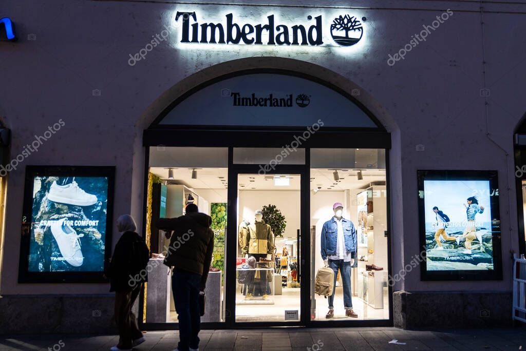 Munich, Germany - April 3, 2025: Sign and logo of a Timberland sportswear or mountain clothing store with people around in Kaufingerstrabe, a shopping street in Munich, Germany
