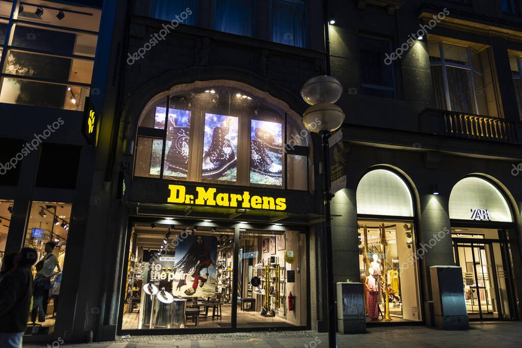 Munich, Germany - April 3, 2025: Illuminated sign of Dr Martens, shoe store at night in Kaufingerstrabe, a shopping street in Munich, Germany