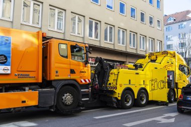 Münih, Almanya - 4 Nisan 2025: Volvo marka ağır çekici bir çöp kamyonunu Münih, Almanya 'da bir caddede kurtarıyor 