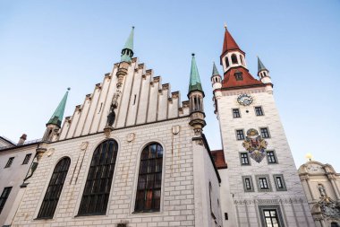 Marienplatz, Münih, Almanya 'da oyuncak bir müzeye ev sahipliği yapan saat kulesi olan 14. yüzyıl Gotik belediye binası cephesi.