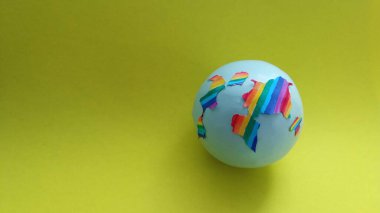 Sarı arka planda renkli topları olan bir dünya. konsept 3d oluşturma.