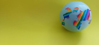 Sarı arka planda renkli topları olan bir dünya. konsept 3d oluşturma.