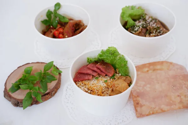 fried noodles with sliced meat and vegetables in a cup