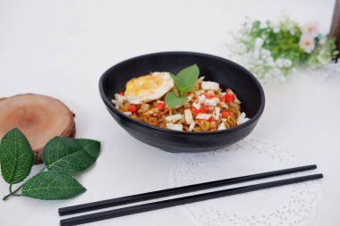 fried noodles with fried egg and vegetables as a background