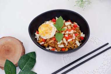 fried noodles with fried egg and vegetables as a background