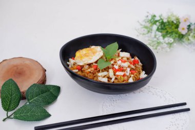 fried noodles with fried egg and vegetables as a background