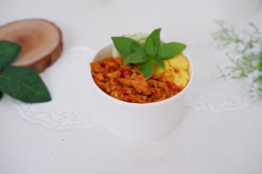 rice with sliced spicy chicken and vegetables as a background