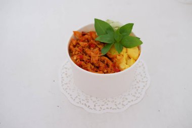 rice with sliced spicy chicken and vegetables as a background