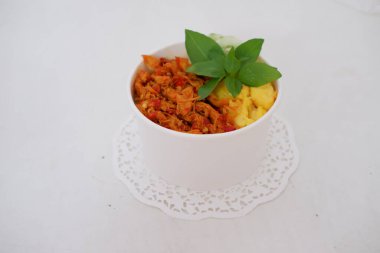 rice with sliced spicy chicken and vegetables as a background