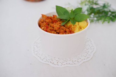 rice with sliced spicy chicken and vegetables as a background