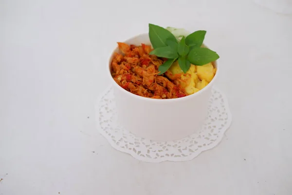 rice with sliced spicy chicken and vegetables as a background