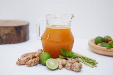 Taze zencefilli zencefil suyu ve beyaz arka planda limon. Sağlıklı içecek..