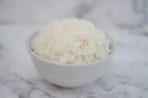 在白色大理石背景的白色碗里的米饭 有选择的重点 — 图库照片