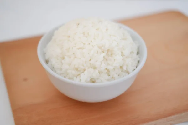 木製板に白いボウルで炊いた米 選択的なフォーカス — ストック写真