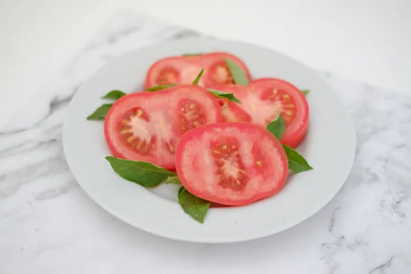 Tomatenscheiben Mit Basilikumblättern Auf Einem Weißen Teller Selektiver Fokus — Stockfoto