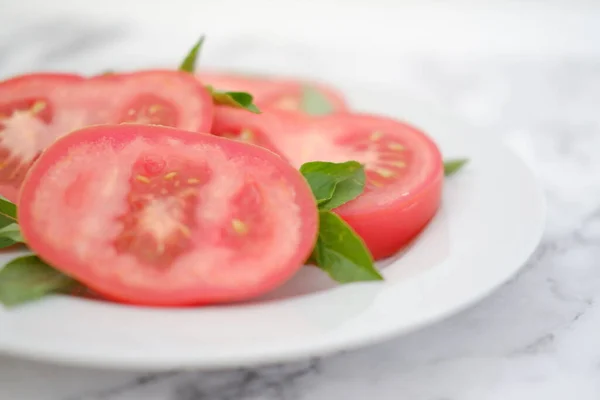 Rebanadas Tomate Con Hojas Albahaca Plato Blanco Enfoque Selectivo —  Fotos de Stock