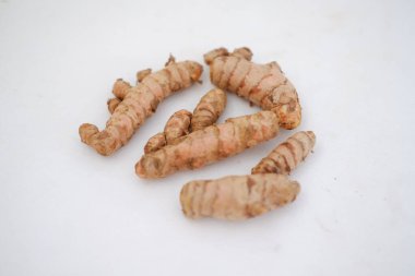  Beyaz arkaplanda izole edilmiş zerdeçal (Curcuma longa Linn) rhizome (kök) dilimlenmiş.