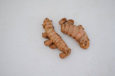  Beyaz arkaplanda izole edilmiş zerdeçal (Curcuma longa Linn) rhizome (kök) dilimlenmiş.