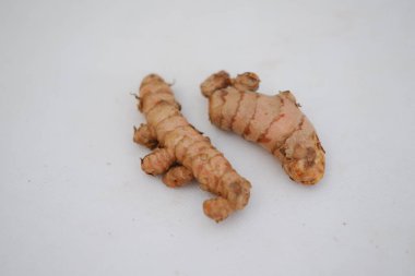  Beyaz arkaplanda izole edilmiş zerdeçal (Curcuma longa Linn) rhizome (kök) dilimlenmiş.