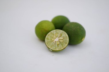 İkiye bölünmüş yeşil kireç ve beyaz arka planda izole edilmiş dilimler..