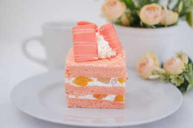 Beyaz arka planda bir parça kek ve çay, stok fotoğrafı.