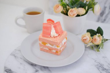 Beyaz arka planda bir parça kek ve çay, stok fotoğrafı.