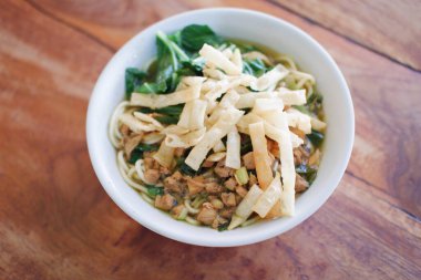 Tahta masada, beyaz kasede kızarmış şehriye.