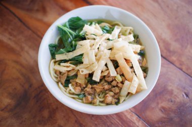 Tahta masada, beyaz kasede kızarmış şehriye.