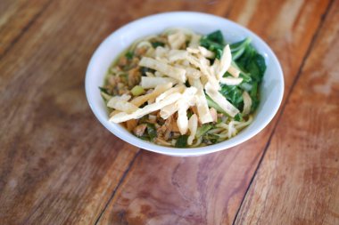 Tahta masada, beyaz kasede kızarmış şehriye.