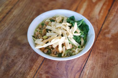 Tahta masada, beyaz kasede kızarmış şehriye.