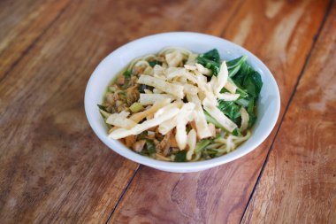 Tahta masada, beyaz kasede kızarmış şehriye.