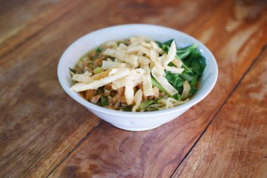 Tahta masada, beyaz kasede kızarmış şehriye.