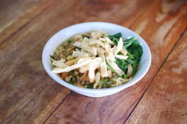 Tahta masada, beyaz kasede kızarmış şehriye.