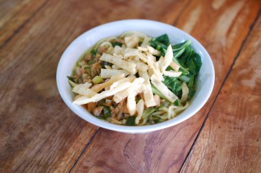 Tahta masada, beyaz kasede kızarmış şehriye.