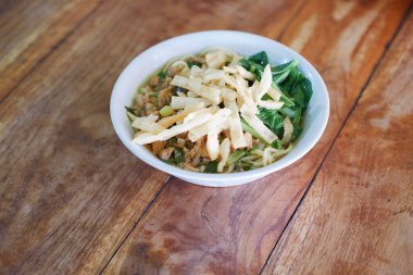 Tahta masada, beyaz kasede kızarmış şehriye.