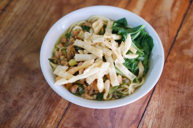 Tahta masada, beyaz kasede kızarmış şehriye.