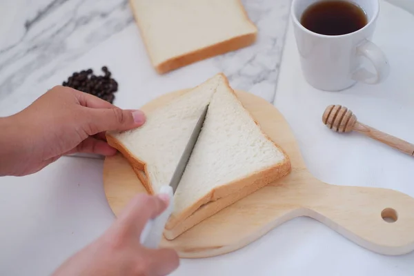 女人在白桌子上用刀和咖啡切面包 — 图库照片