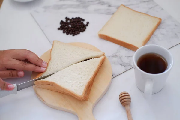 Frau Schneidet Brot Mit Messer Und Tasse Kaffee Auf Weißem — Stockfoto