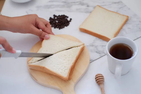 Frau Schneidet Brot Mit Messer Und Tasse Kaffee Auf Weißem — Stockfoto