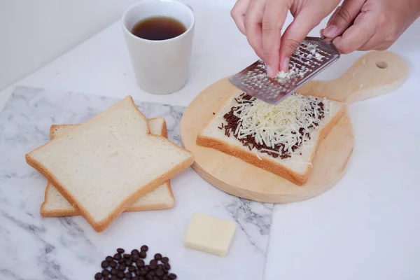 白い背景にバターとチョコレートでトーストを作る女性の手 — ストック写真