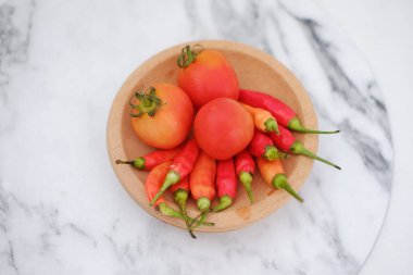 Sebzeler ve baharatlar ahşap kasede beyaz mermer masa arkasında