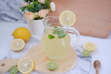 Limonata ve beyaz arka planda taze limon ve nane yaprakları.