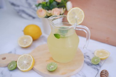 Limonata ve beyaz arka planda taze limon ve nane yaprakları.
