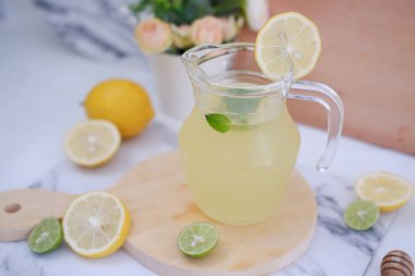 Limonata ve beyaz arka planda taze limon ve nane yaprakları.