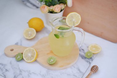 Limonata ve beyaz arka planda taze limon ve nane yaprakları.