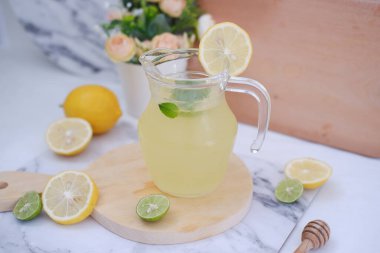 Limonata ve beyaz arka planda taze limon ve nane yaprakları.