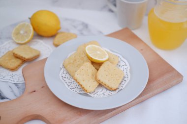 Beyaz arka planda çıtır kraker ve limon suyu..