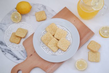 Beyaz arka planda çıtır kraker ve limon suyu..